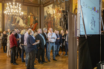 Personen im Festsaal beim Betrachten der Leinwand