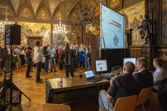 Personen im Festsaal beim Betrachten der Leinwand