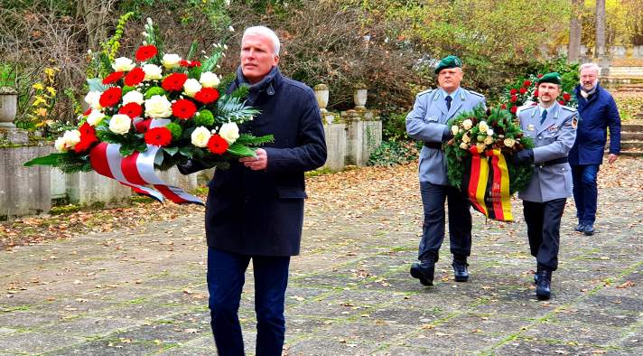 Männliche Person trägt Blumengesteck