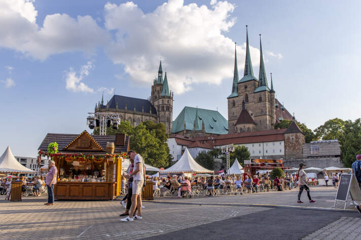 Jahrmarkt auf einem Platz vor einer großen Kirche.