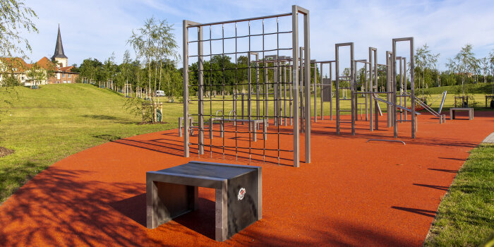 eine Fläche mit verschiedenen Fitnessgeräten in einem Park