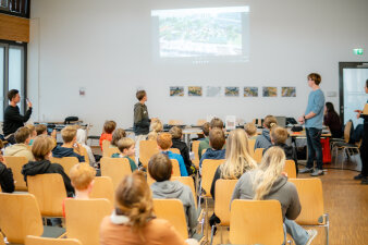 Ein Jugendlicher hält eine Präsentation vor Publikum