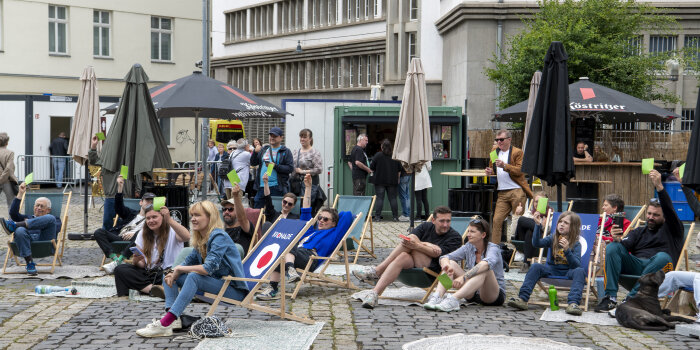 Menschen sitzen in Liegestühlen