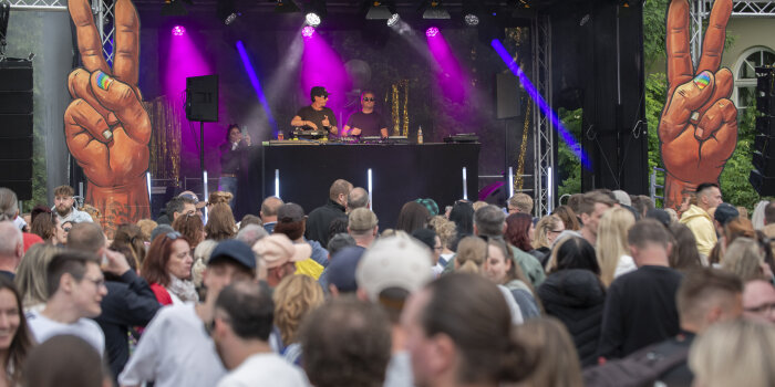 Eine Bühne mit DJs, davor Menschen