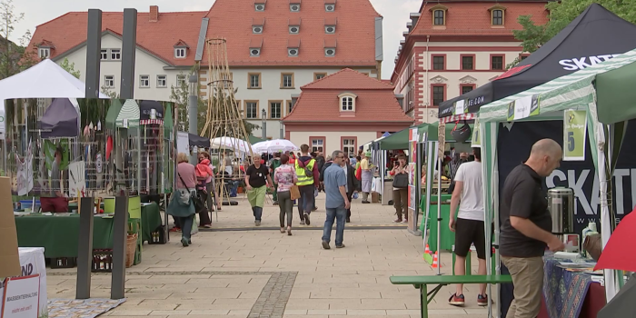 Snapshot aus dem Video mit Ständen und Menschen