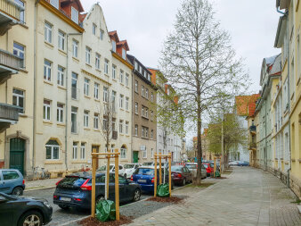 eine Straße in Erfurt mit Mehrfamilienhäusern, parkenden Autos und Bäumen