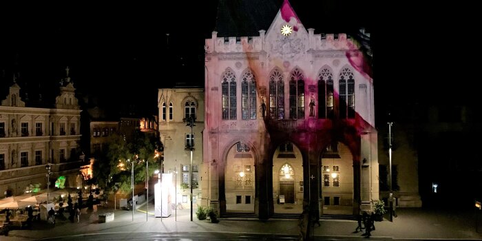 Das Erfurter Rathaus bei Nacht, die Fassade bunt illuminiert. 