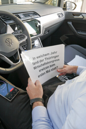 Person hält einen Zettel "In welchem Jahr fand der Thüringer Wirtschaftskongress erwicon zum ersten Mal statt?"