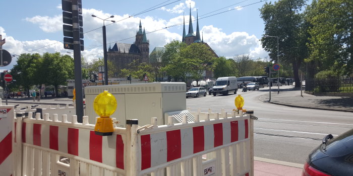 Baustellenabsperrung mit Dom und Severikirche im Hintergrund