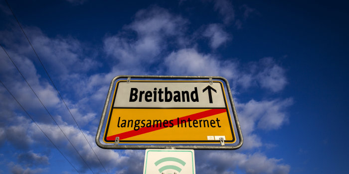 Schild ähnlich wie Ortsausgangsschild mit der Aufschrift Breitband und langsames Internet durchgestrichen