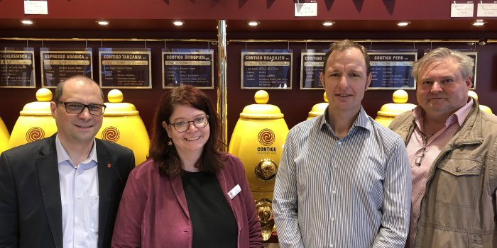 Foto: Contigo Unternehmensbesuch Steffen Linnert 07.03.2018 © Stadtverwaltung Erfurt 4 Personen, die vor Kaffeebohnenfässern mit der Aufschrift "Contigo" stehen