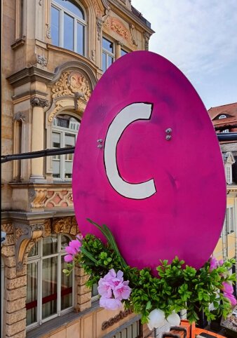 eine eiförmige Konstruktion in Pink mit dem Buchstaben "C" in Weiß