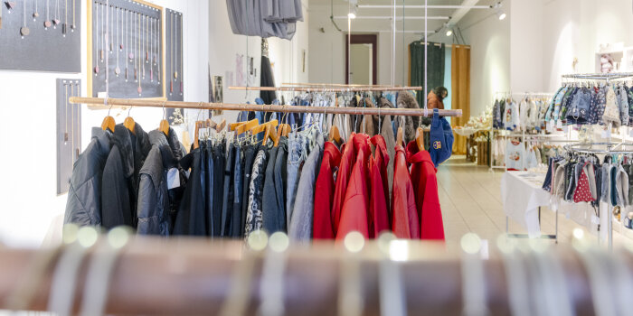 in einem Ladengeschäft stehen mehrere Kleiderständer mit Kleidung