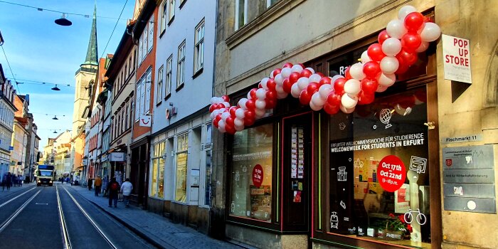 Mit Luftballons dekoriertes Ladengeschäft in einer Häuserzeile. 