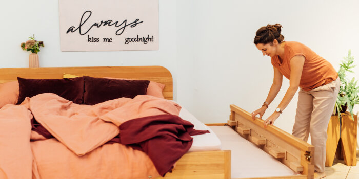 eine Frau zieht ein Holzbett aus