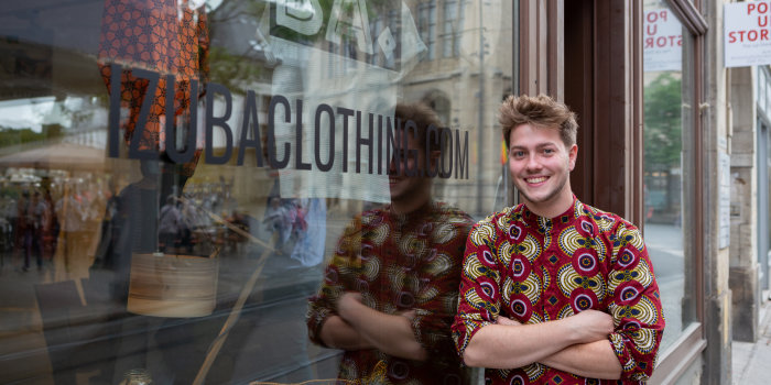 Ein Mann steht an ein Schaufenster eines Ladenlokals gelehnt. 