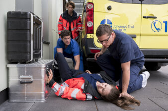 Medizinisches Personal vor einem Rettungswagen