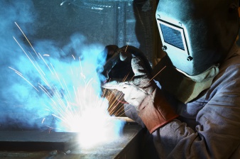 Arbeiter mit Schweißmaske und Schweißgerät bei der Arbeit