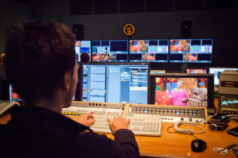 Bildbearbeitung in einem dunklen Raum mit vielen Monitoren