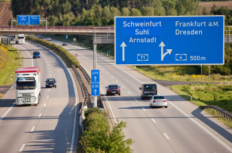 A 71 am Erfurter Kreuz mit Lkw und Pkw. Auf den blauen Hinweisschildern sind die weiteren möglichen Richtungen Frankfurt, Dresden, Schweinfurt/Suhl lesbar. 