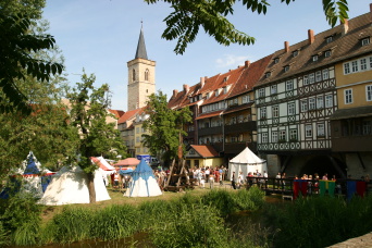 Foto: Krämerbrückenfest © Stadtverwaltung Erfurt Halbinsel vor der Krämerbrücke mit mittelalterlichen Zelten und Besuchern.