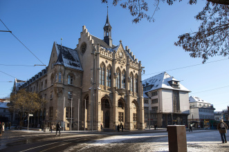 Blick auf das Rathaus aus nordöstlicher Sicht, die Front ist mit Sonne beschienen und der verschneite Fischmarkt zum Teil zu sehen.