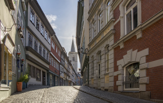 Häuserzeile mit Kopfsteinpflaster mit Blick auf Kirchturm