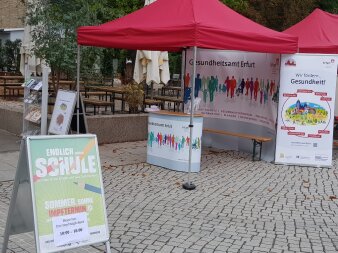 ein Infostand im Freien mit verschiedenen Aufstellen und Roll-ups