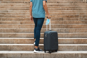 Foto: Reise: © nito/123RF Person mit Koffer geht Stufen hinauf