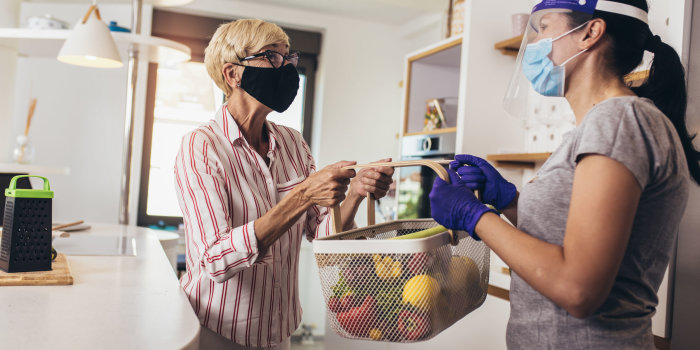 Foto: Coronavirus: Helfen, Einkaufen, Liefern © Jovan Mandic/123RF Kurier liefert Einkauf an ältere Frau mit Gesichtsmaske.
