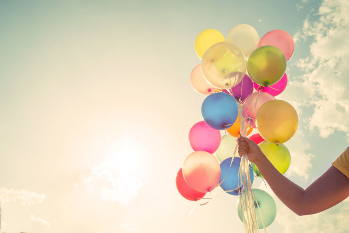 Hand mit bunten Ballons vor Himmel Hand mit bunten Ballons vor Himmel