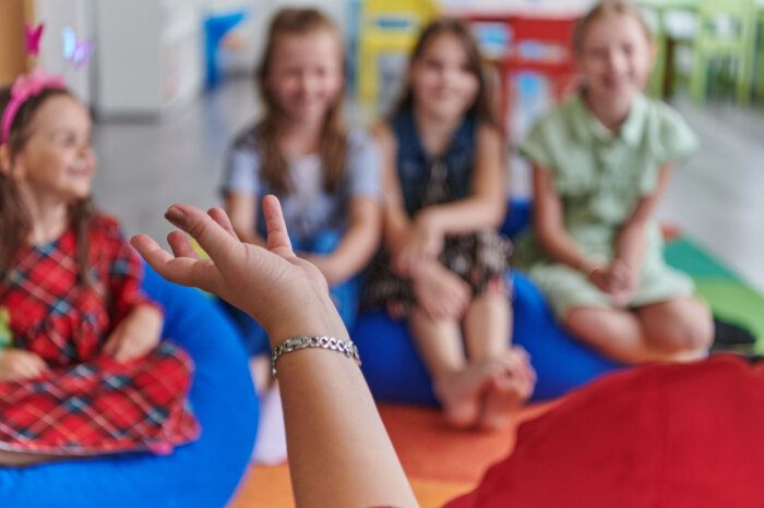 Gruppe von Kindern mit Hand einer Person im Vordergrund Gruppe von Kindern mit Hand einer Person im Vordergrund