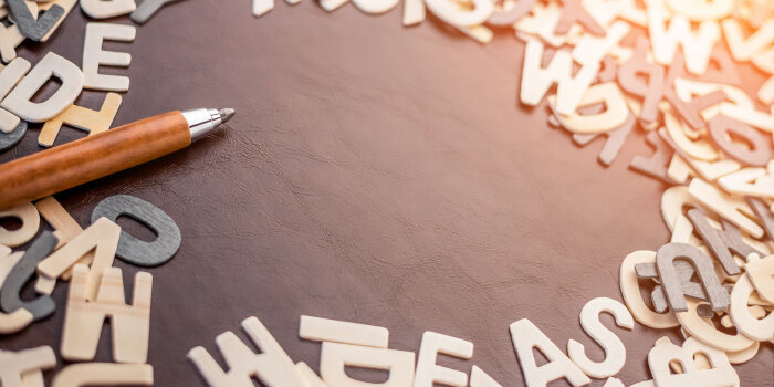 Foto: Buchstaben mit Stift © Stadtverwaltung Erfurt/whyframeshot/123rf Viele einzelne Buchsaben liegen im Kreis. In die Mitte des Kreises zeigt ein Stift.