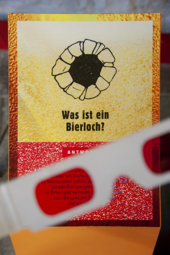 Blick durch eine Brille auf eine Ausstellungstafel