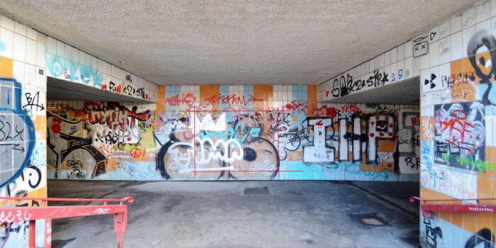 ein mit Fliesen ausgekleideter und mit Graffiti besprühter Fußgängertunnel