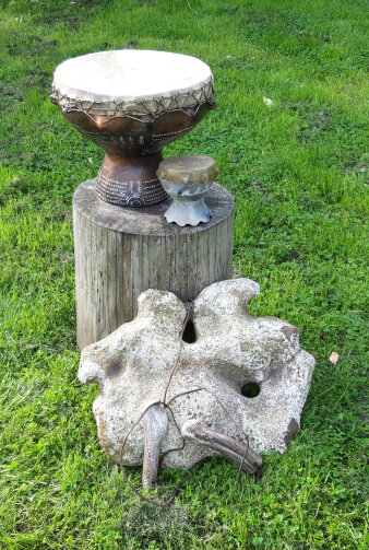 Zwei historische Trommeln und ein Klangstein auf einer grünen Wiese