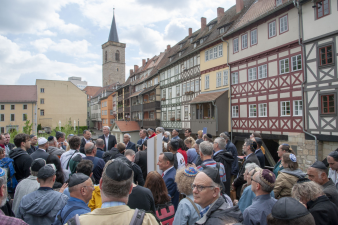 Menschenansammlung, viele Personen tragen eine Kippa, eine kleine Mütze, auf dem Kopf,im Hintergrund bebaute Brücke