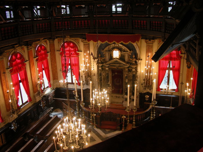 Sinagoga Spagnola in Venedig Geschmückter Innenraum der Synagoge Spagnola in Venedig mit Toraschrein, brennenden Kerzen an den Kronleuchtern und roten Fenstervorhängen