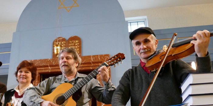 Foto: Misrach-Trio © Anke Pfannstiel Zwei Männer und eine Frau mit Instrumenten, im Hintergrund Toraschrein der Neuen Synagoge Erfurt