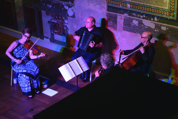 Veretski Pass Vier Musiker spielen gemeinsaam auf ihren Instrumenten: Violine, Akkordeon, Kontrabass und Klarinette.
