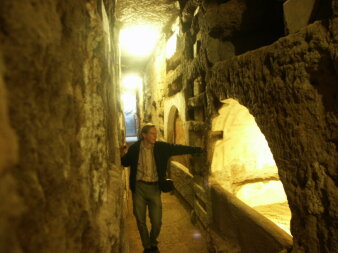 Eine Person steht in den jüdischen Katakomben in Rom