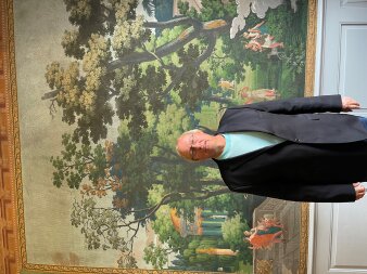 Porträtaufnahme vom Referenten Dipl. Ing. Architekt Norbert Huschner vor einem farbigen Gemälde.