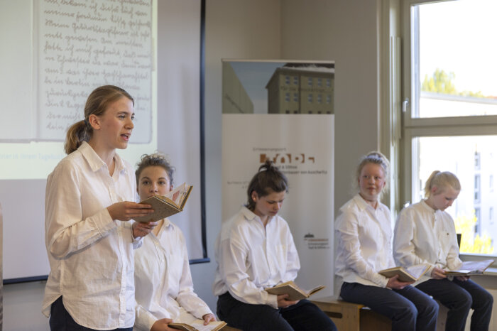 Lesung des Theaters die Schotte zu „Miriams Tagebuch“ Fünf Jugendliche in weißen Hemden und dunklen Hosen lesen aus Büchern vor