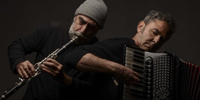 Zwei männliche jüdische Musiker mit ihren Instrumenten in einem Motiv aus dunklen Farbtönen