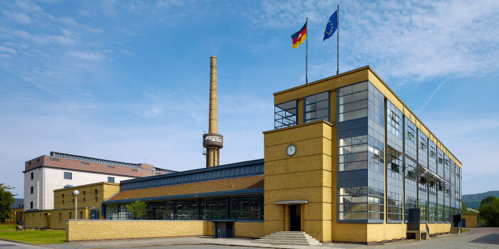 eine Fabrik mit einer Fassade aus Stein und Glas