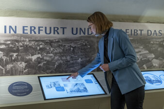 eine Frau tippt auf einen Bildschirm in einer Ausstellung