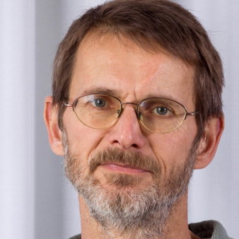 Foto: Georg Rössler © Georg Rössler Nahaufnahme eines leicht in die Kamera lächelnden Mannes. Er hat kurze braune Haare, eine Brille und einen Bart.