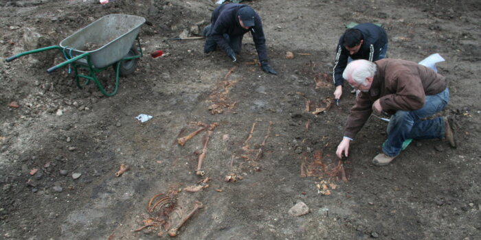 Foto: Grabung auf dem mittelalterlichen jüdischen Friedhof © Dr. Karin Sczech drei Männer legen auf dem Erdboden Skelette frei