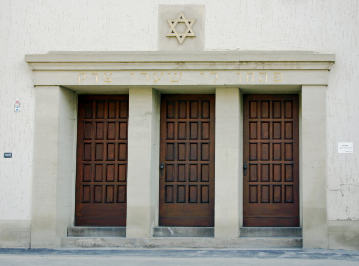 Drei Türen aus Holz nebeneinander, gesäumt von Säulen, darüber der Davidstern