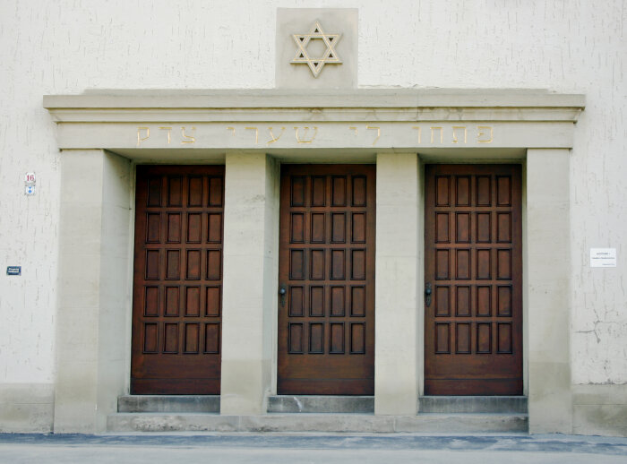 Eingang in die Neue Synagoge Drei Türen aus Holz nebeneinander, gesäumt von Säulen, darüber der Davidstern